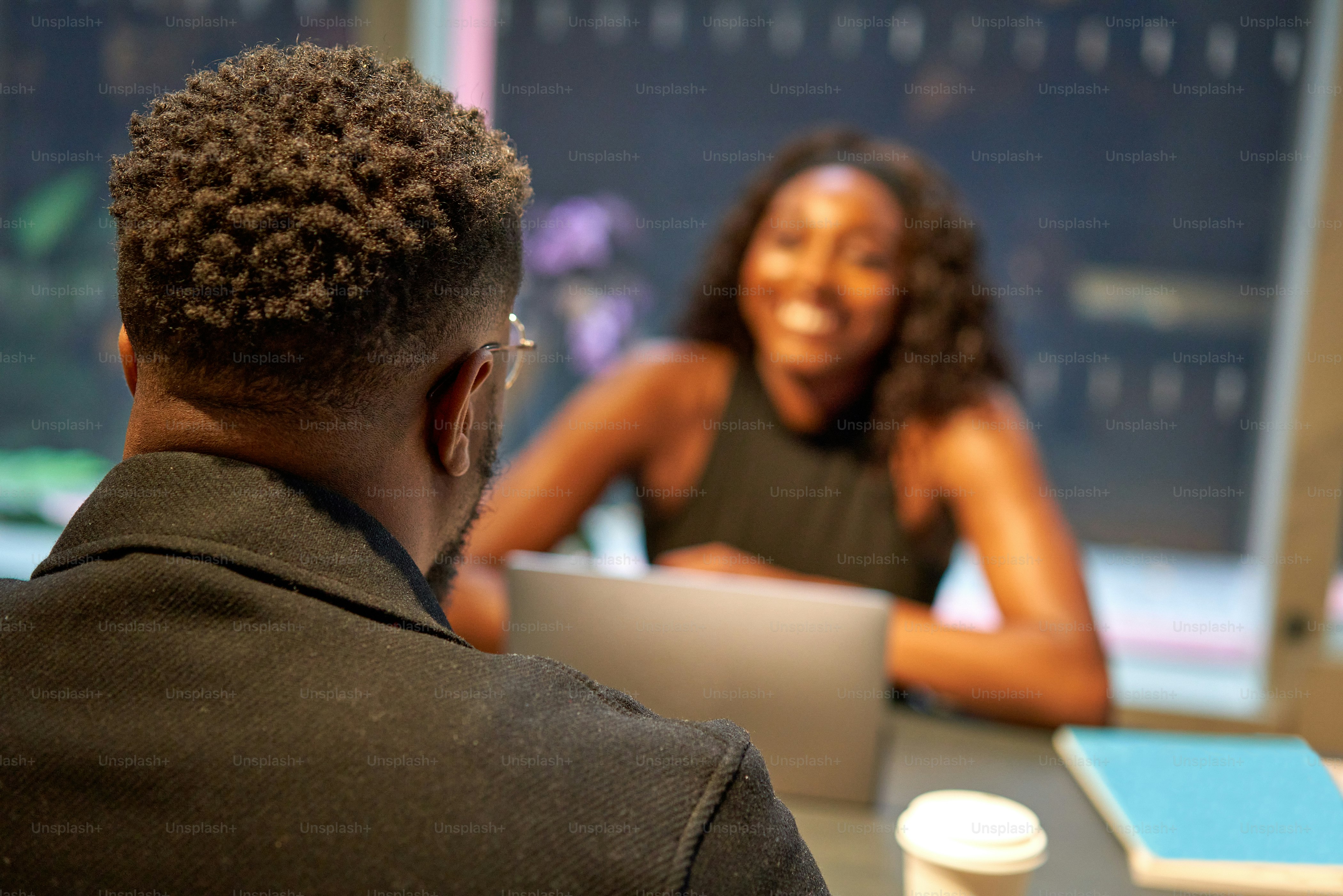 Un hombre y una mujer sentados en una mesa con una computadora portátil