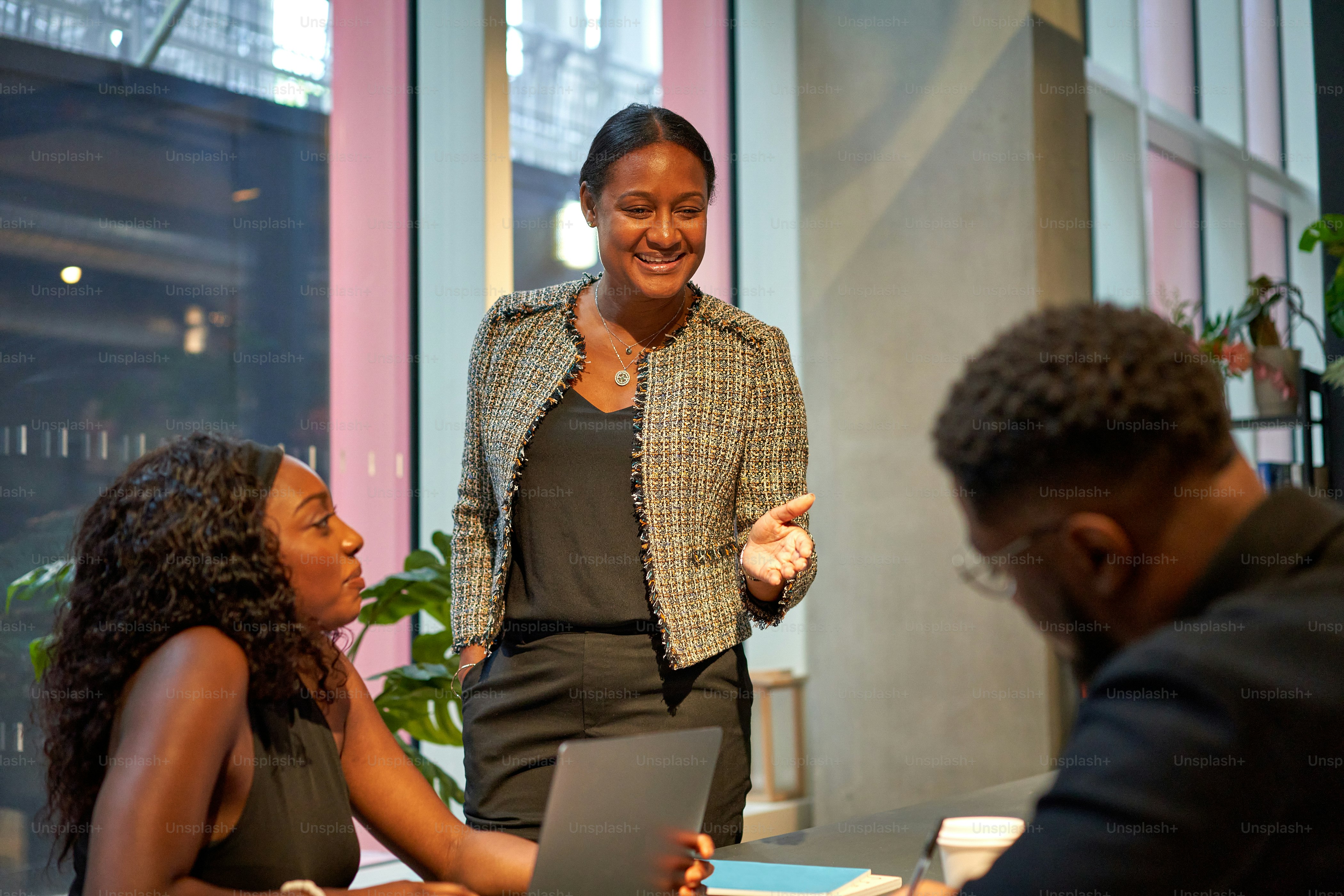 Eine Gruppe von Menschen, die mit Laptops um einen Tisch sitzen