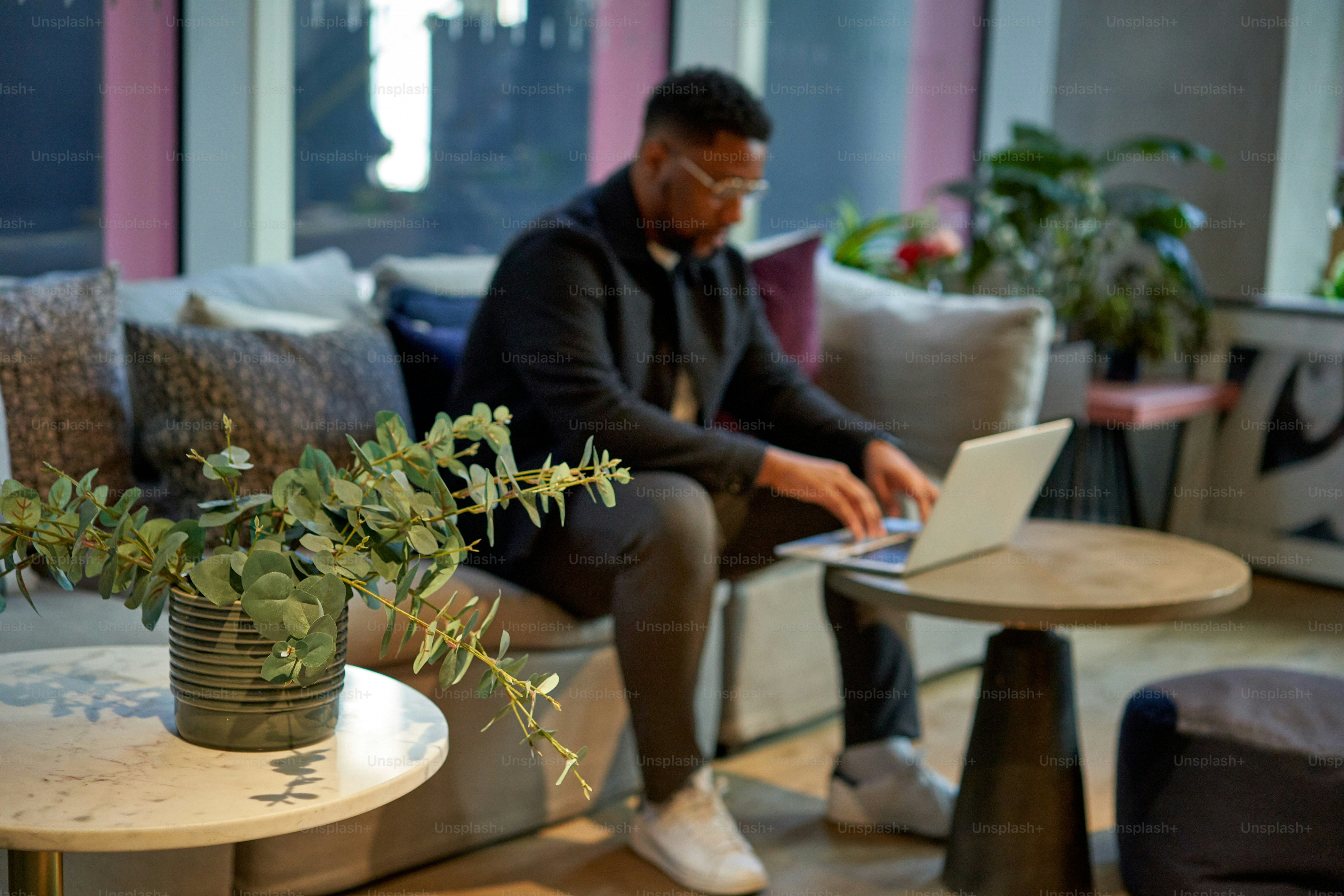 a man sitting on a couch using a laptop computer