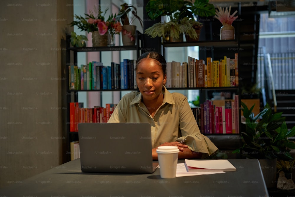 Una persona sentada en una mesa con una computadora portátil