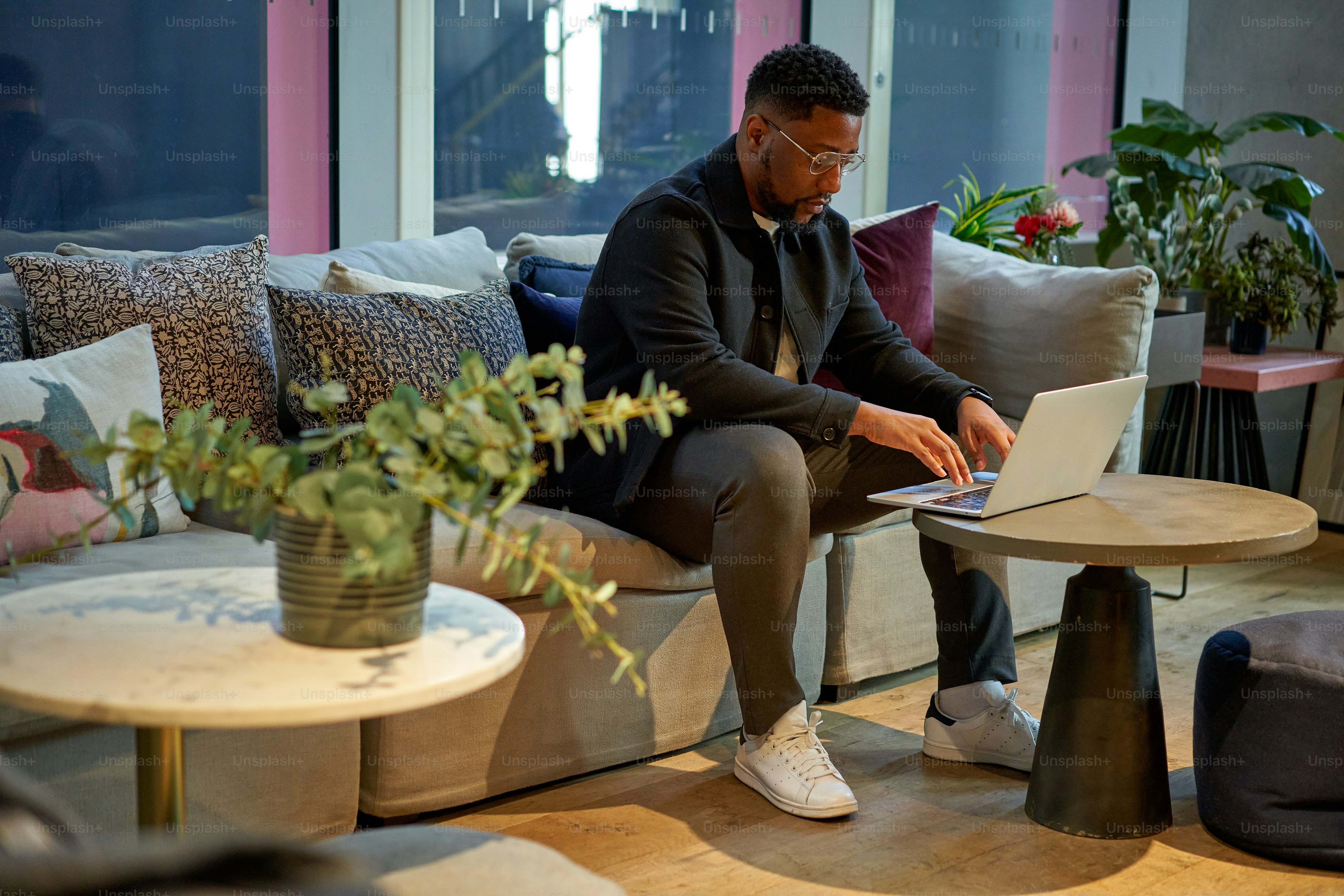 Un hombre sentado en un sofá usando una computadora portátil