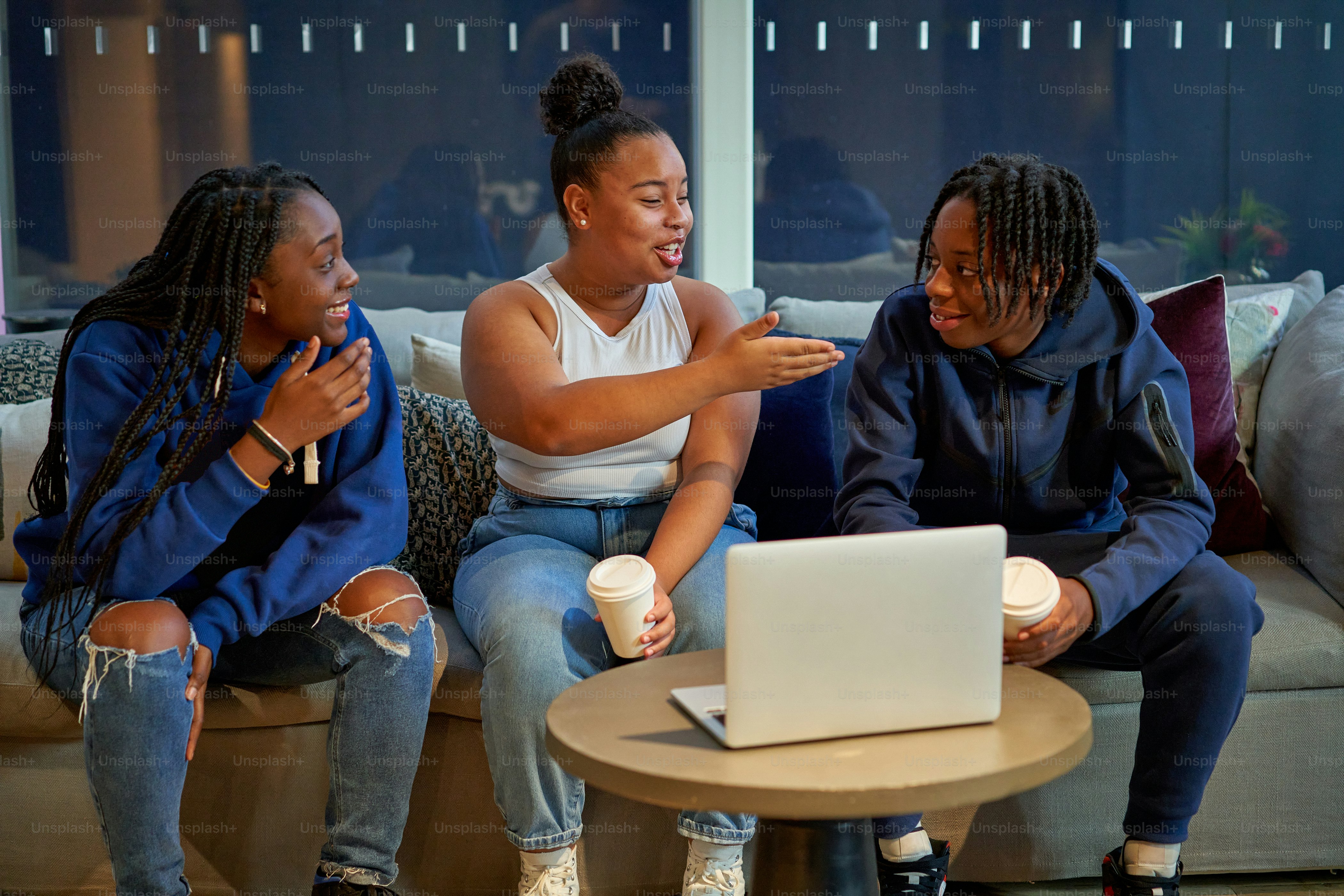 Eine Gruppe von Frauen sitzt nebeneinander auf einer Couch