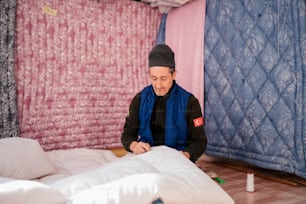 Un hombre sentado en una cama en una habitación