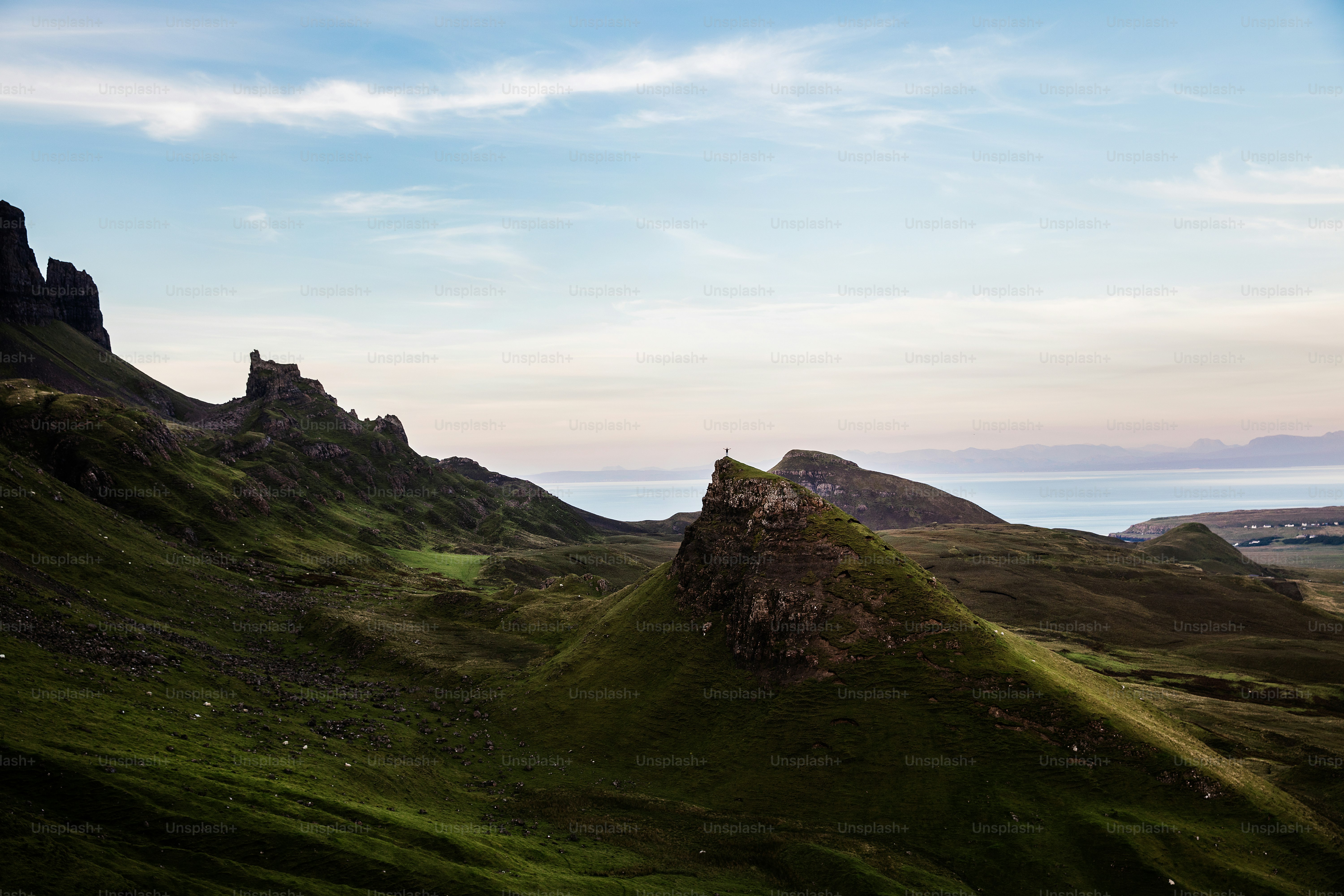 a grassy hill with a few rocks on top of it
