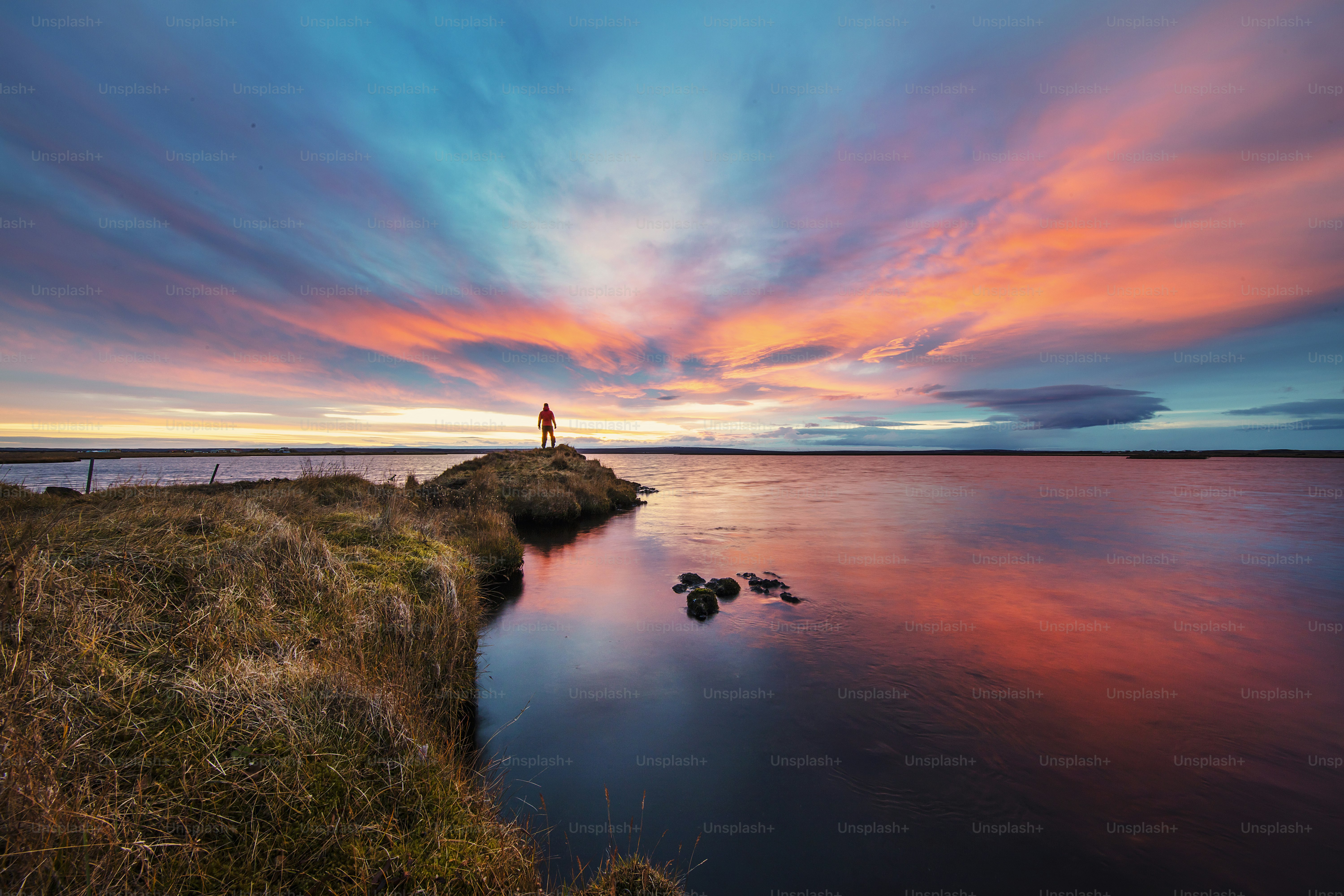 a person standing on a small island in the middle of a body of water