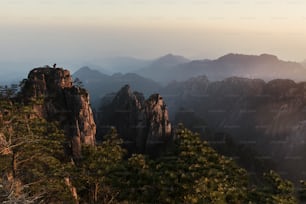 a view of a mountain range with trees and mountains in the background