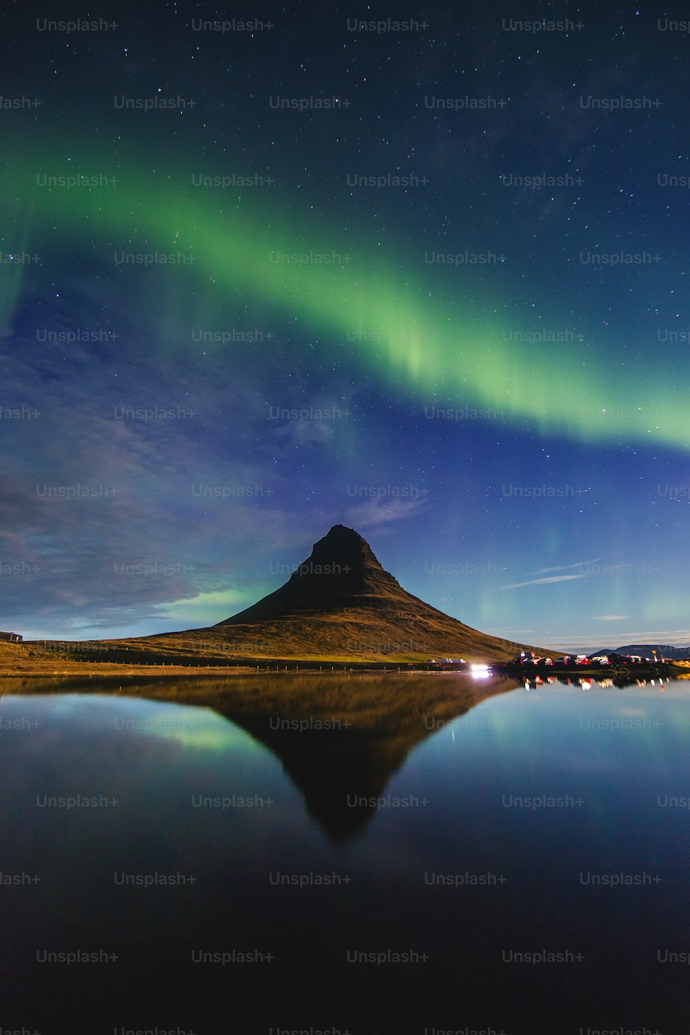 uma montanha com uma luz de aurora verde no céu