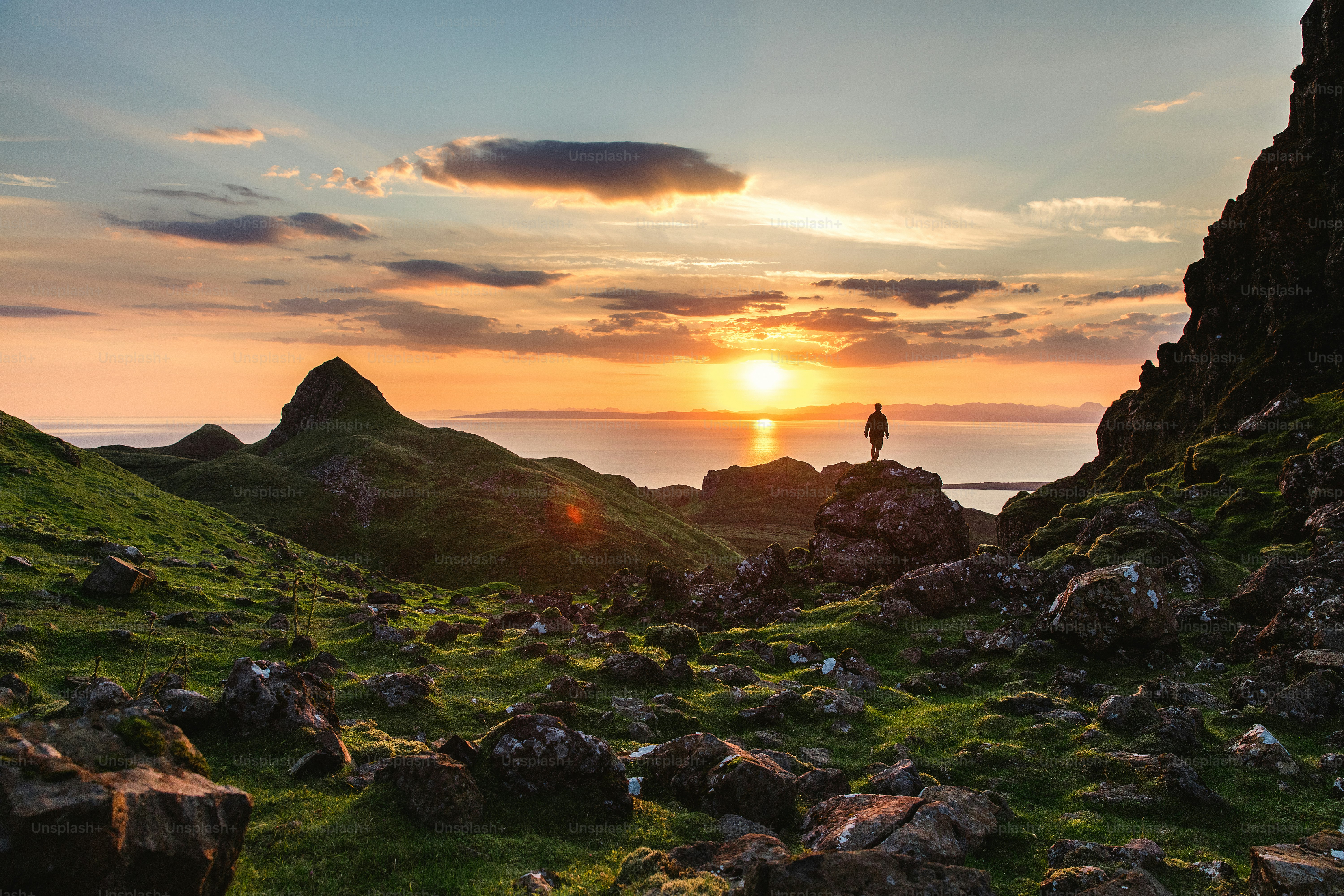 a man standing on top of a lush green hillside