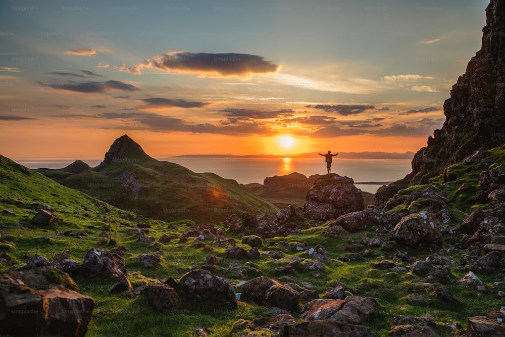 a man standing on top of a lush green hillside