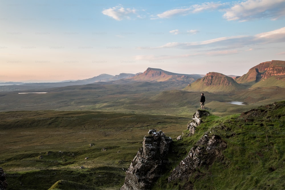 a person standing on top of a green hill