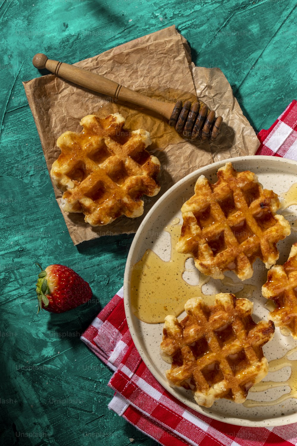 a plate of waffles on a red and white checkered table cloth