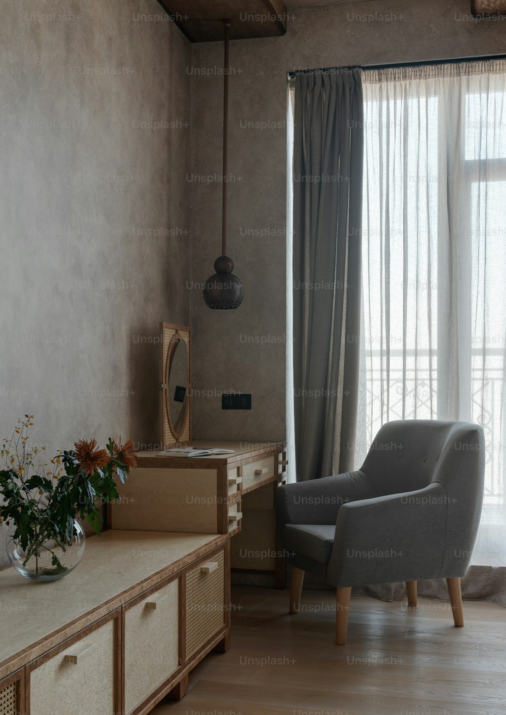 a living room with a chair, dresser and a mirror