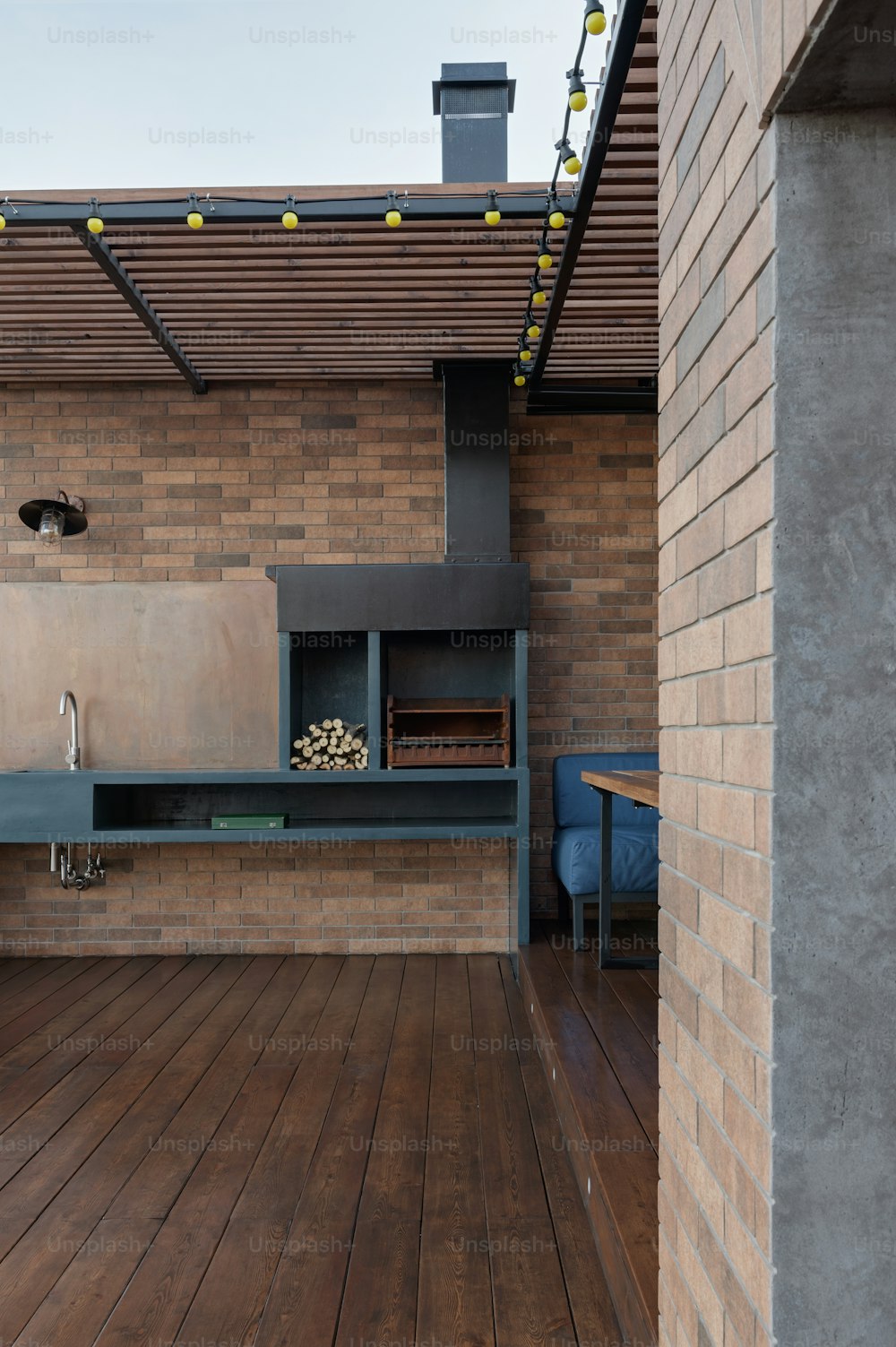 eine Außenküche mit Holzboden und Ziegelmauer