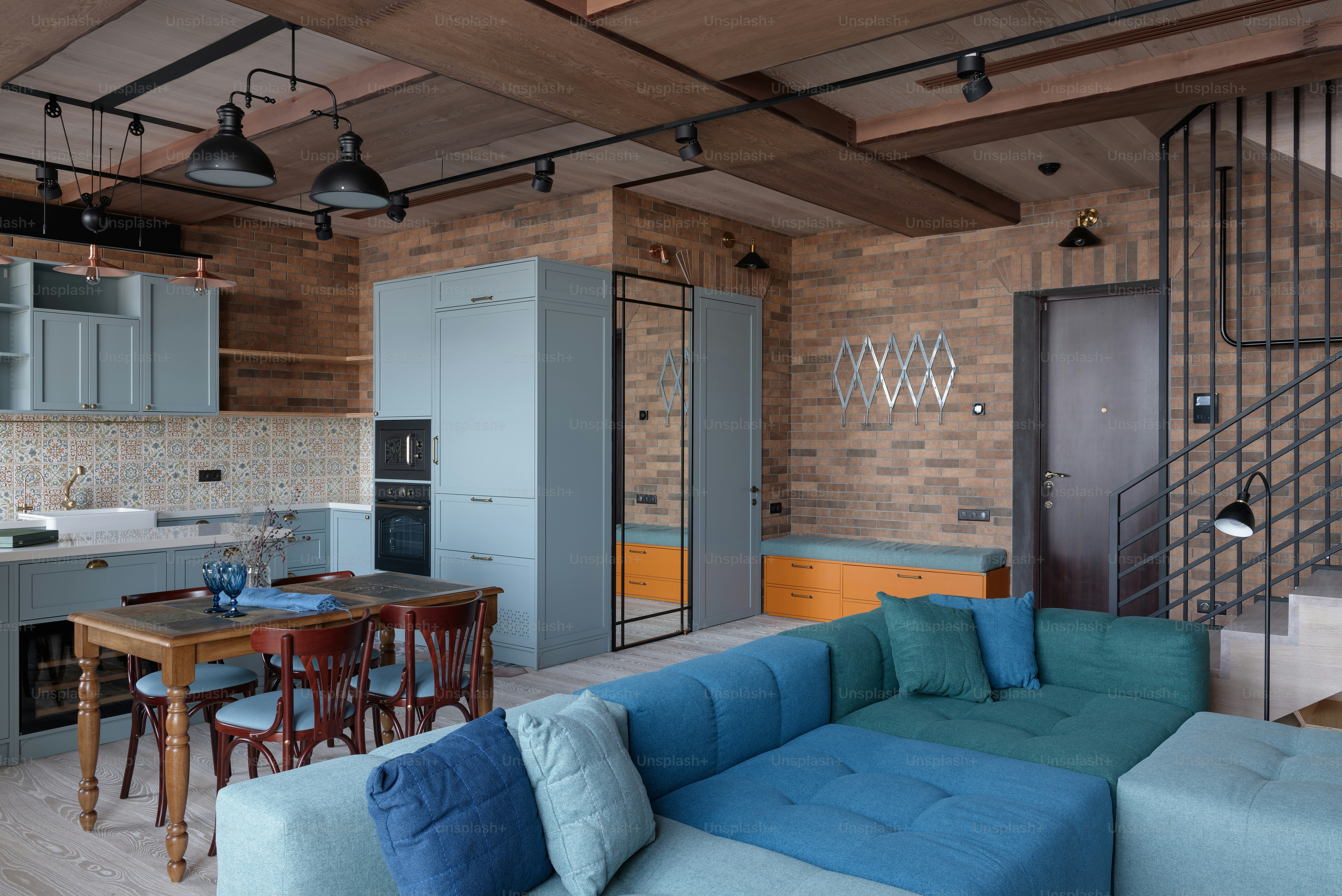 a living room filled with furniture next to a kitchen