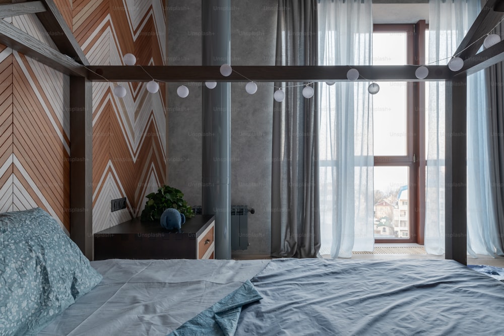 a bedroom with a bed and a large window