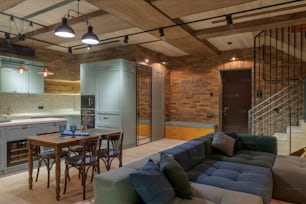 a living room filled with furniture next to a kitchen