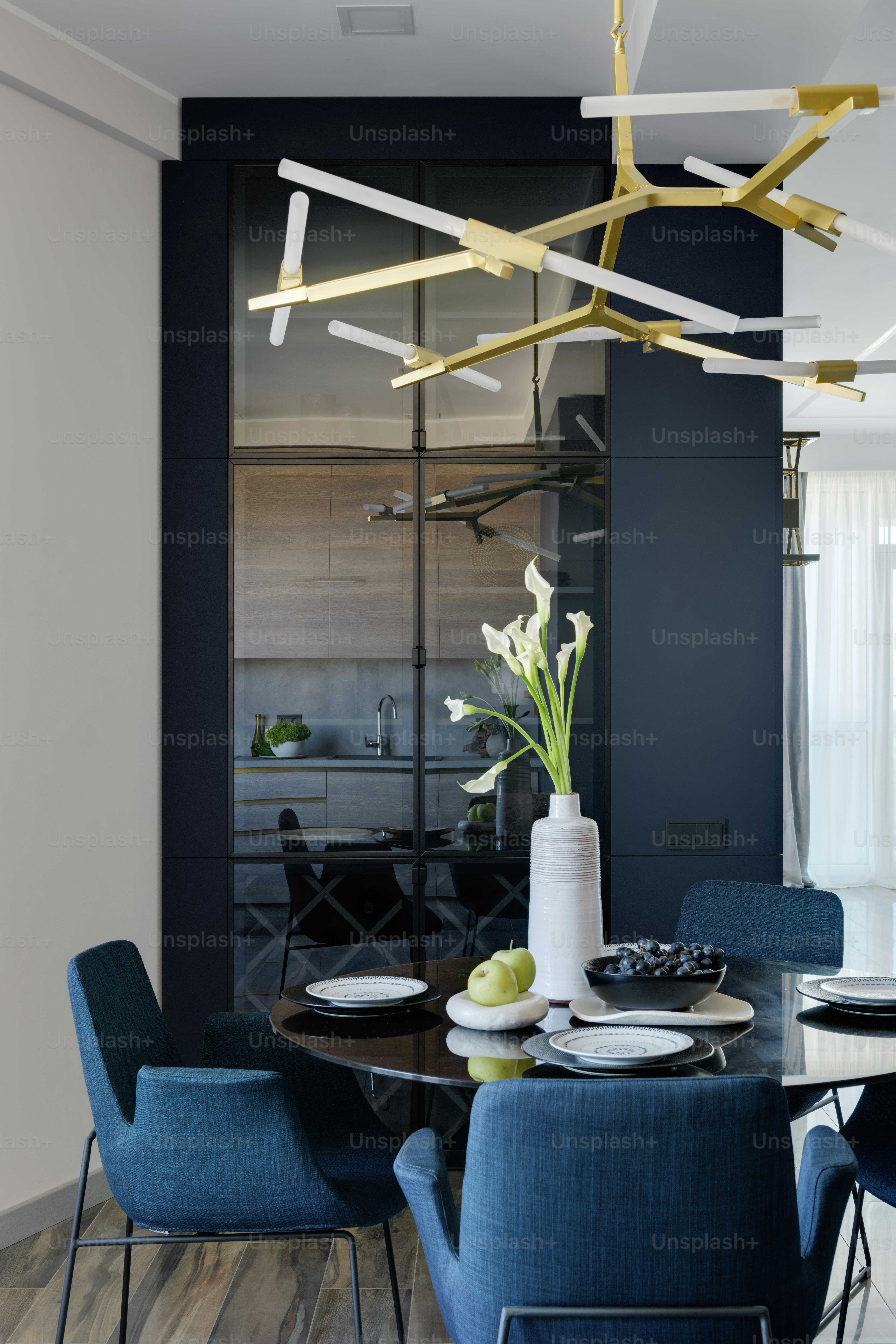 una mesa de comedor con sillas azules y un jarrón de flores