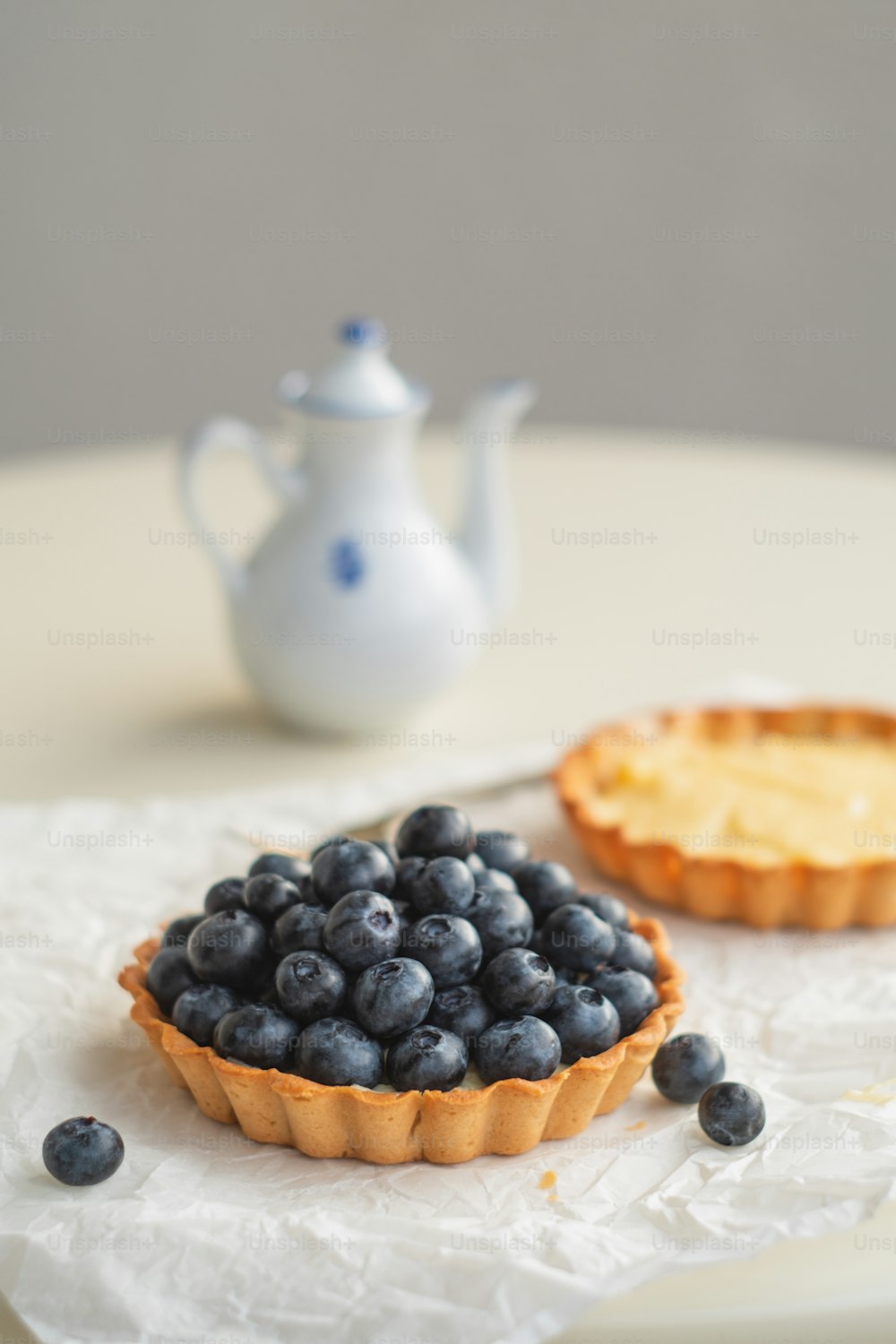 a tart with blueberries and a cup of tea