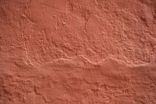 una pared de estuco rojo con un pequeño parche de pintura