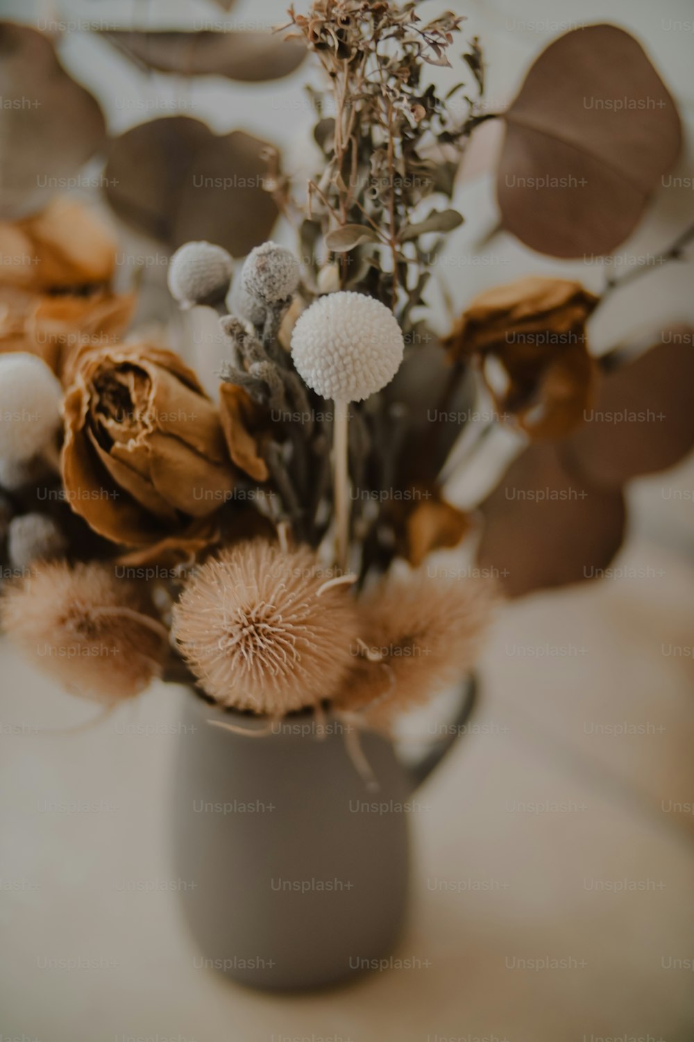 a vase filled with lots of flowers on top of a table