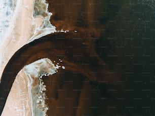 Luftaufnahme eines Strandes mit Wellen und Sand
