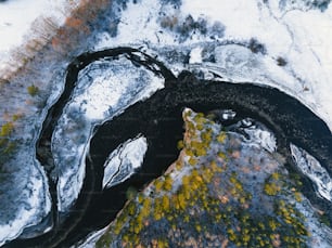 an aerial view of a river running through a snow covered field