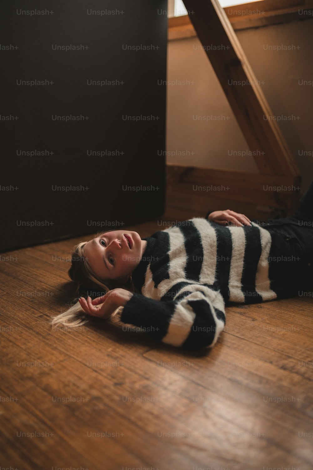 a woman laying on the floor in a striped sweater