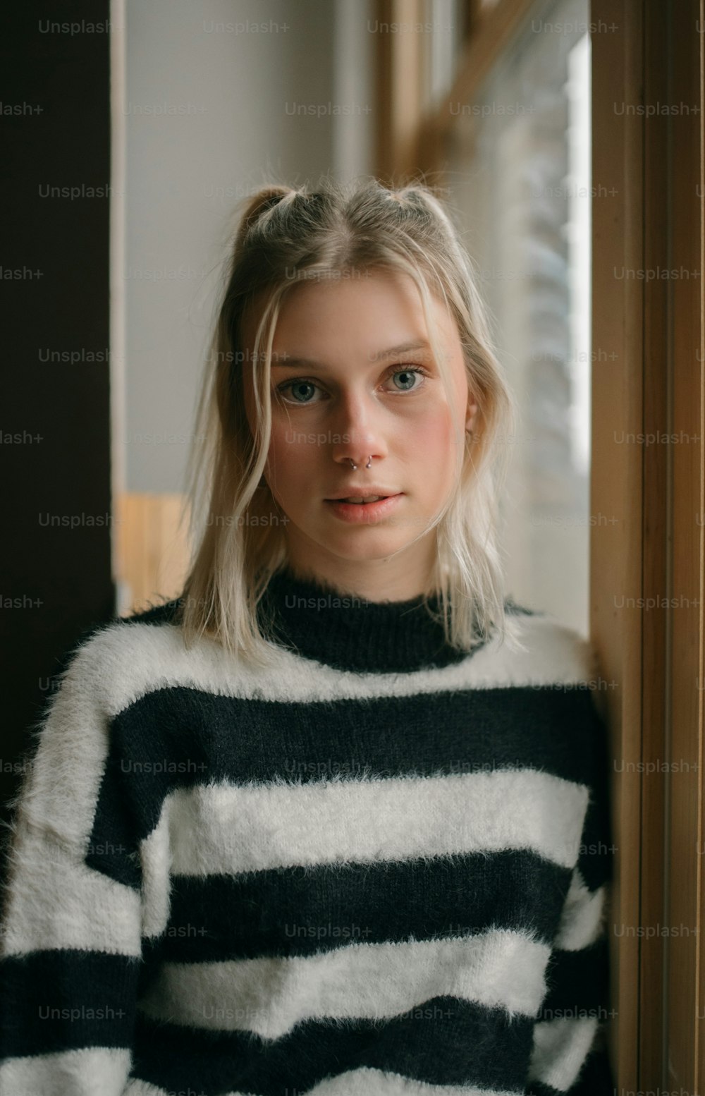 a woman with blonde hair wearing a black and white striped sweater