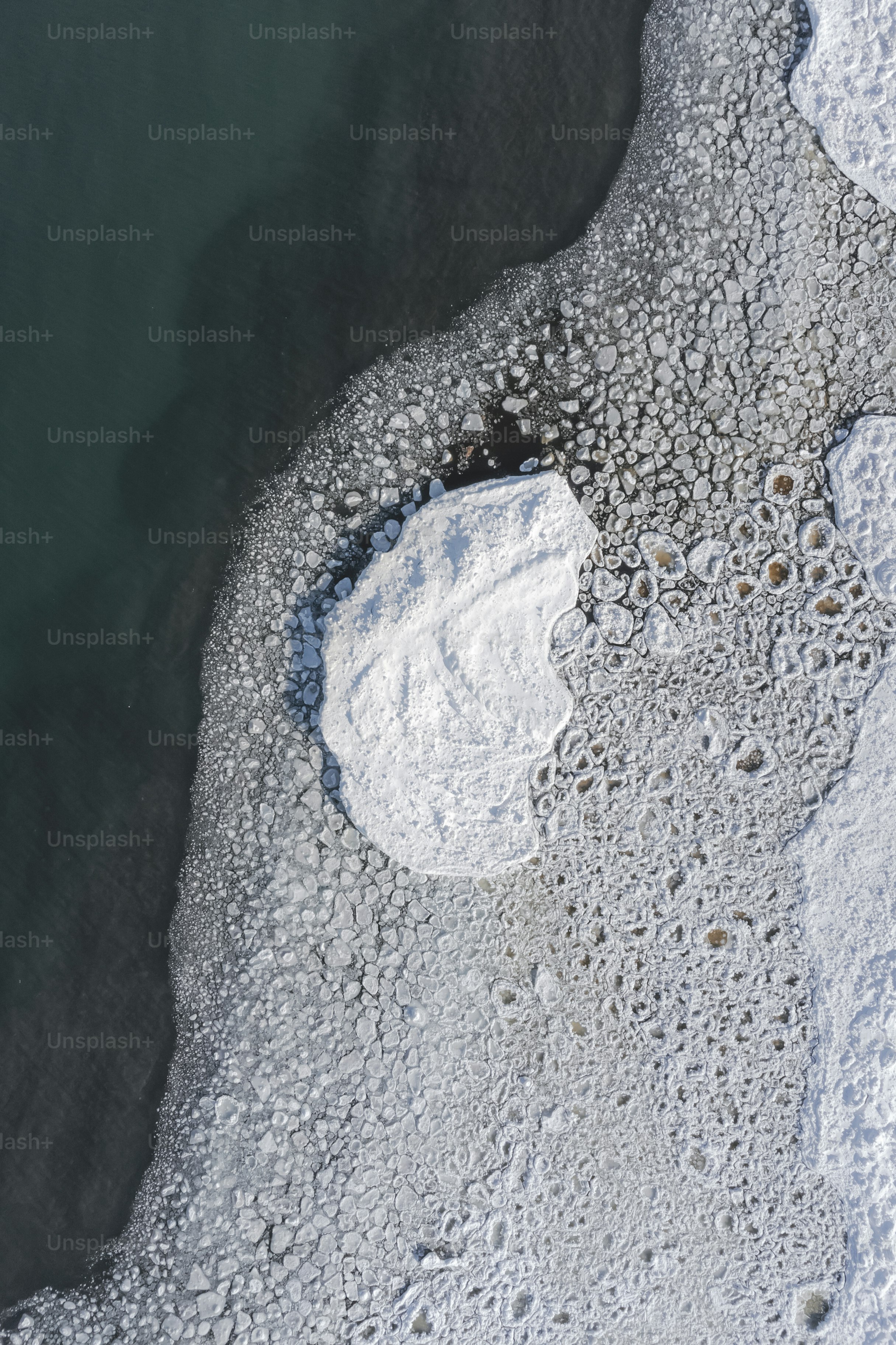 an aerial view of a body of water surrounded by ice