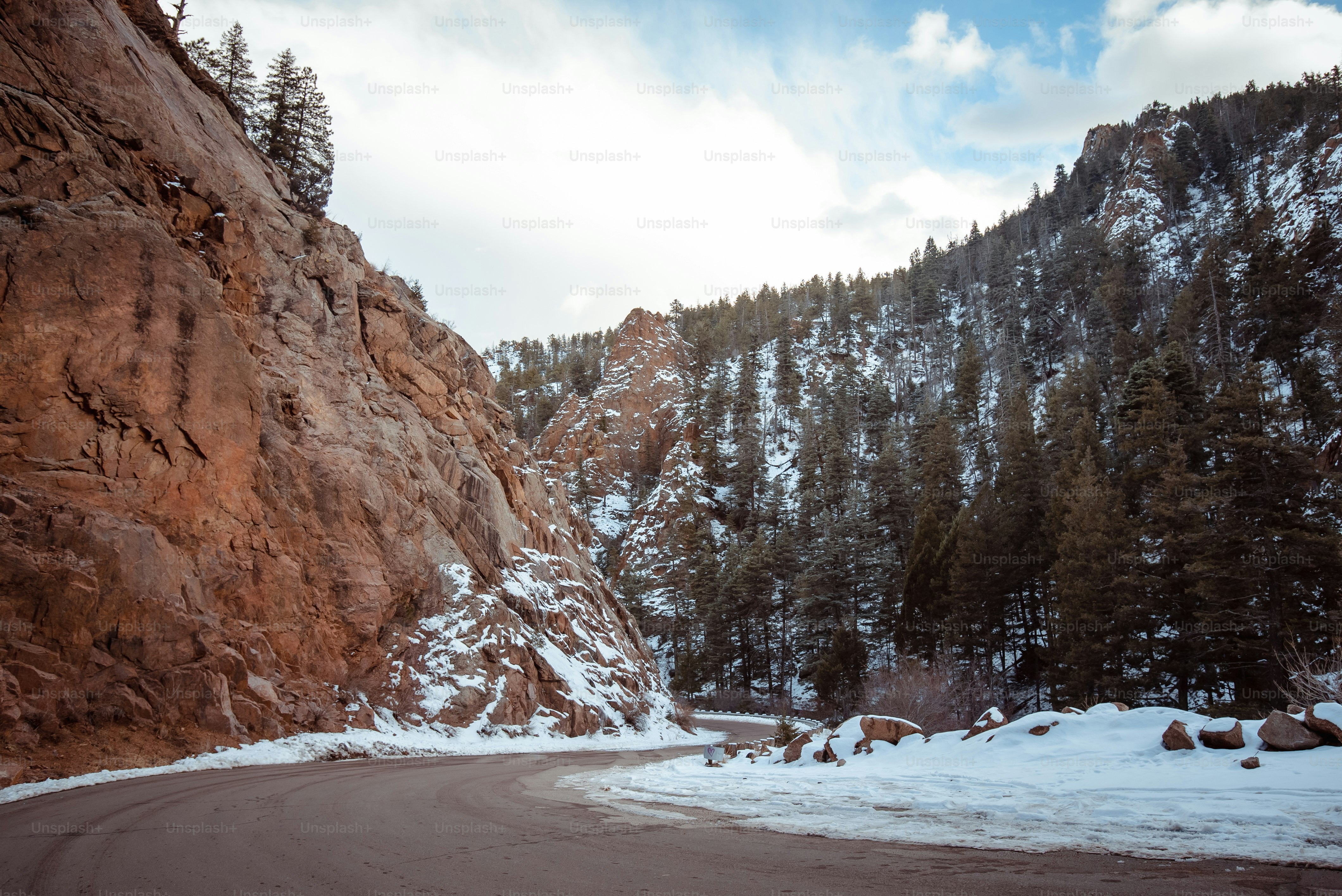 a mountain road with snow on the ground