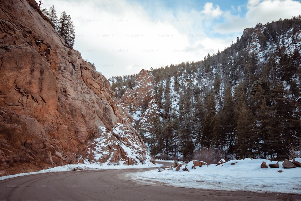 a mountain road with snow on the ground