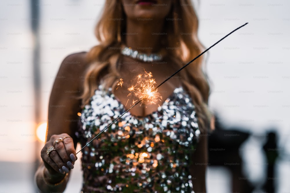 a woman holding a sparkler in her hand