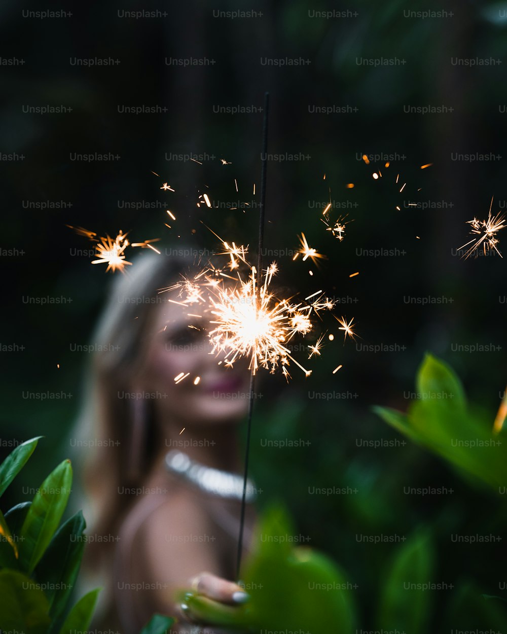 a woman holding a sparkler in her hand