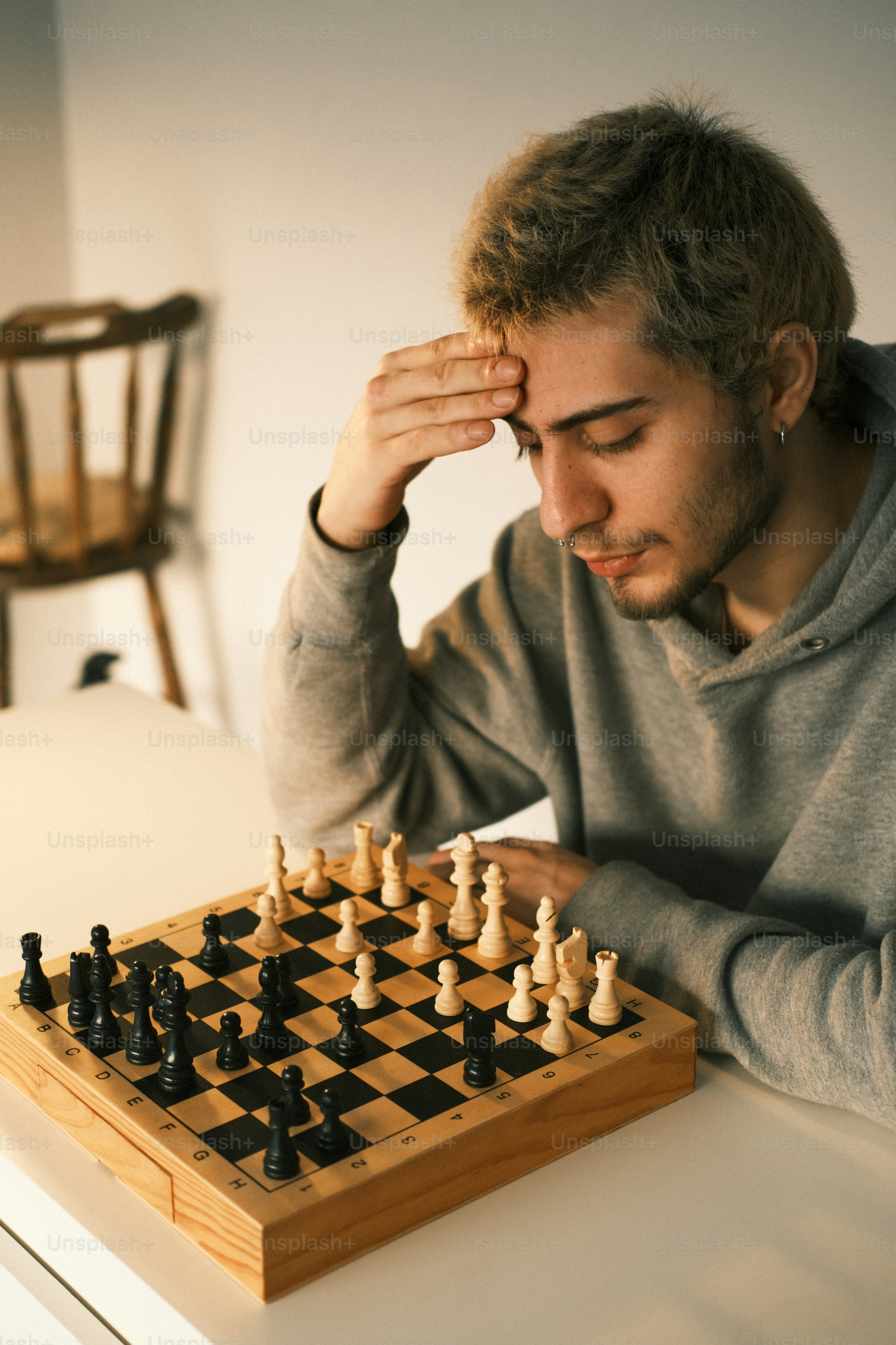a man sitting at a table playing a game of chess