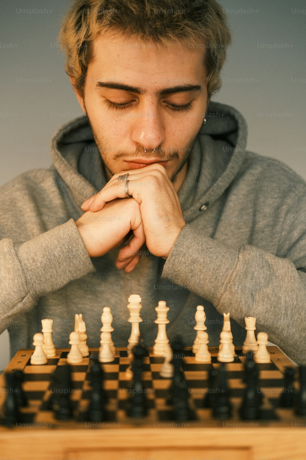 체스 보드가있는 테이블에 앉아있는 남자