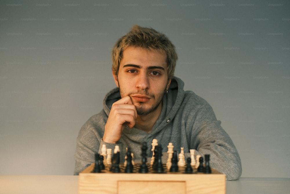 a man sitting at a table with a chess board