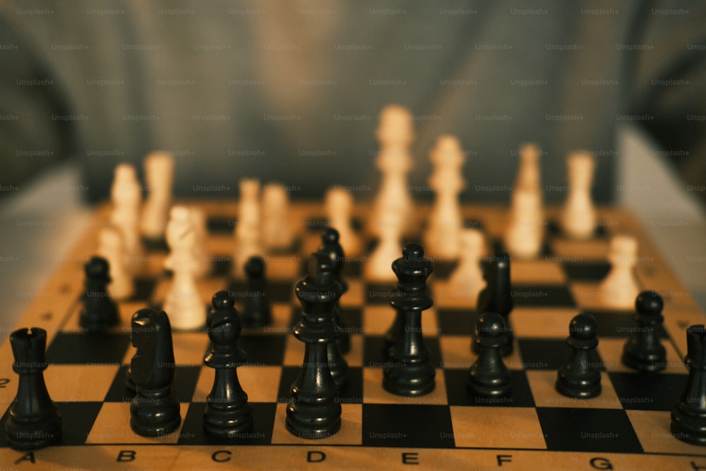 a wooden chess board with black and white chess pieces