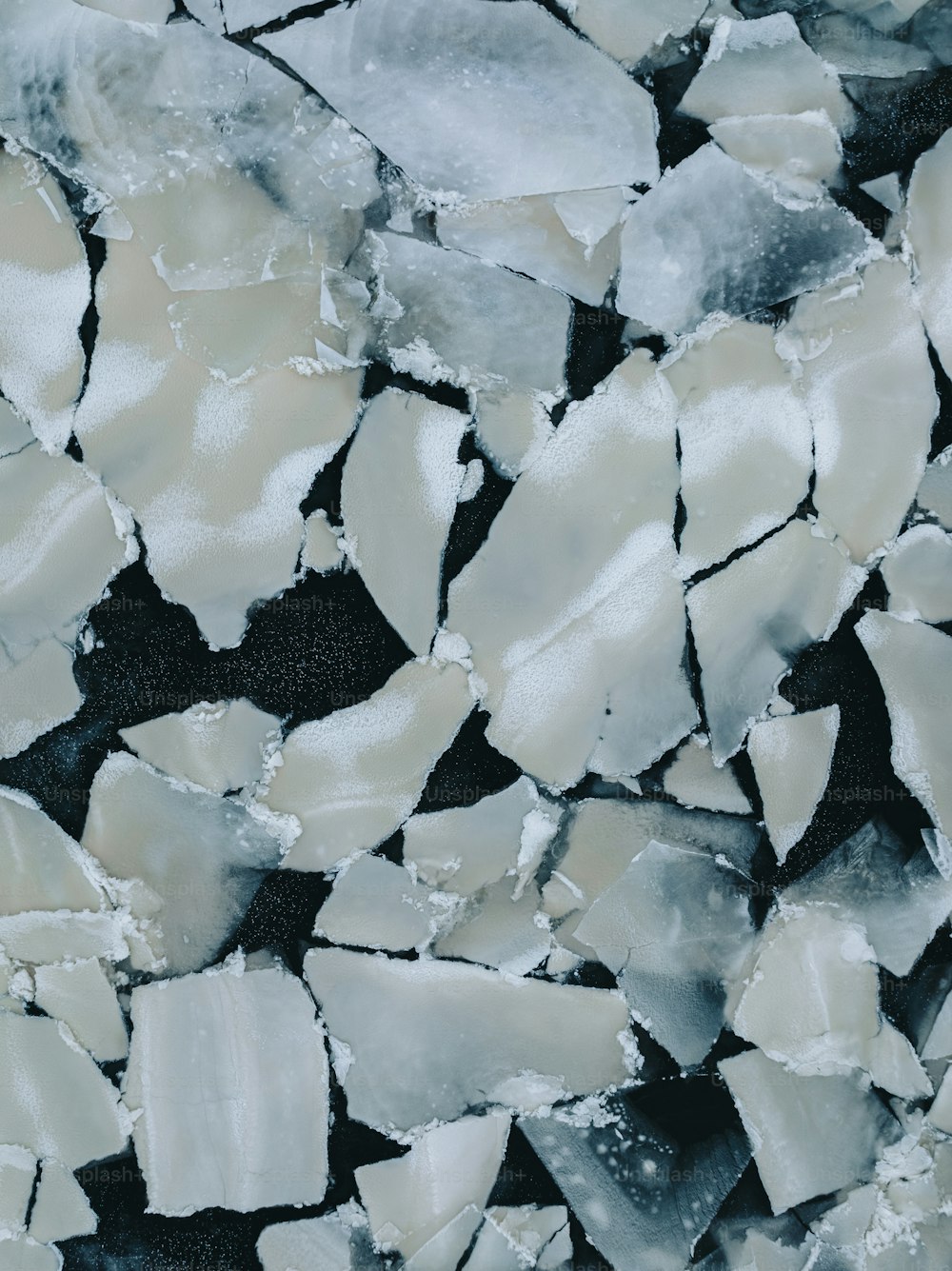 uma pilha de pedaços de gelo sentados em cima de uma superfície preta