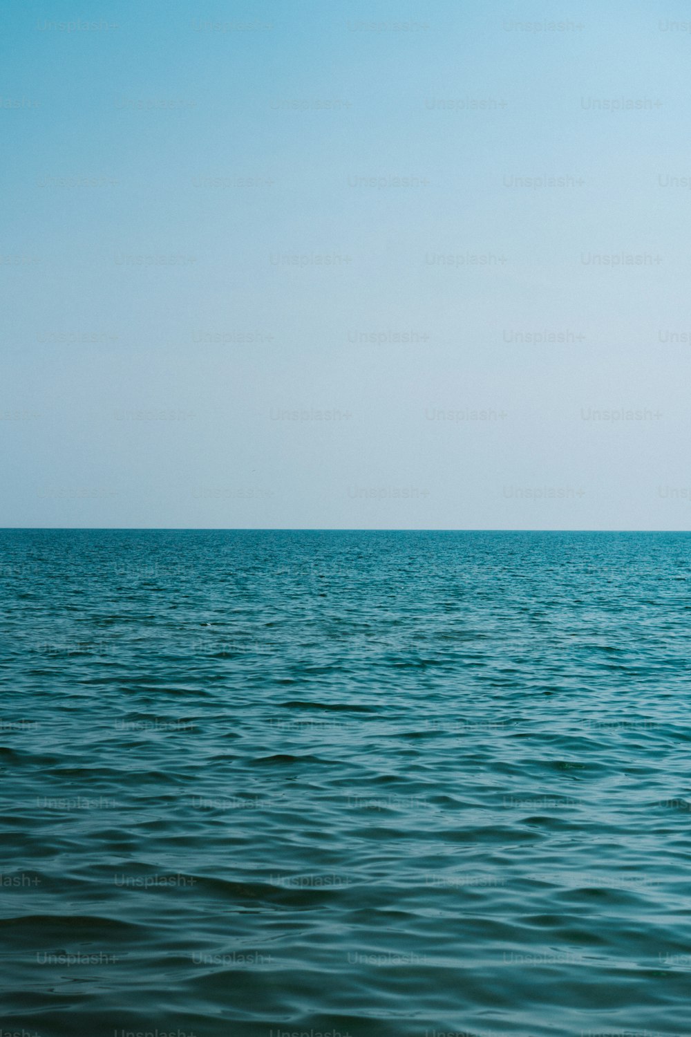 a large body of water sitting under a blue sky