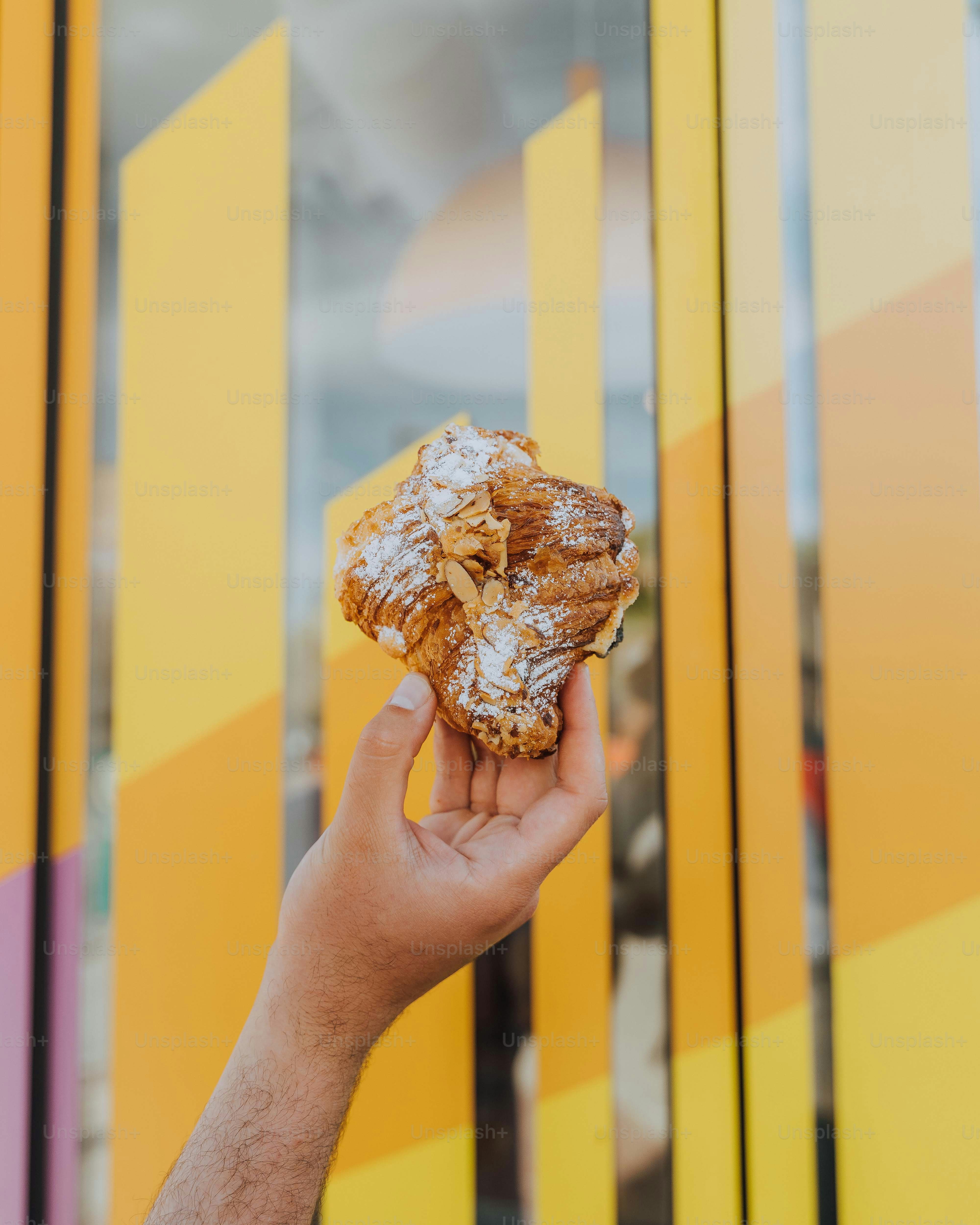 a person holding a pastry in their hand