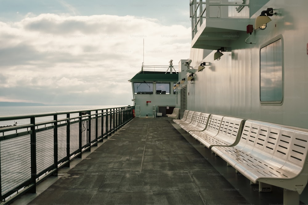 a long white bench sitting on the side of a boat