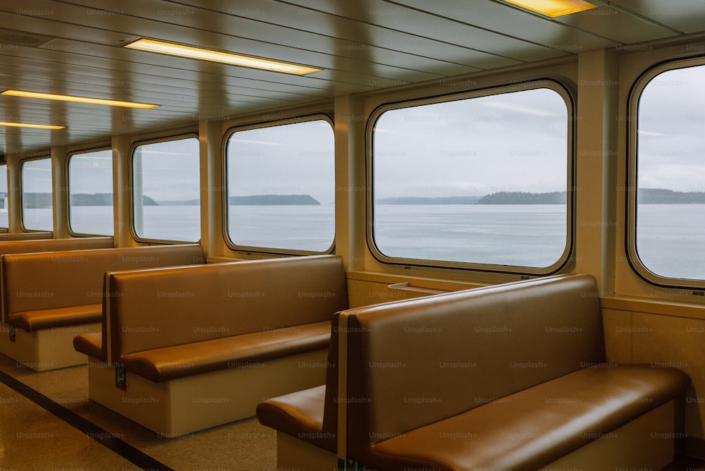 Una fila di sedili seduti in cima a un treno accanto a un finestrino