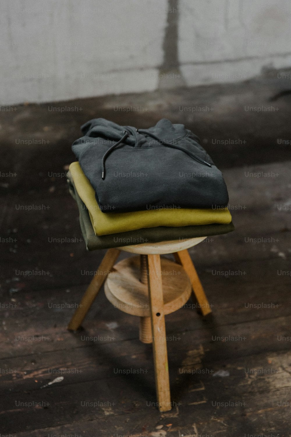 나무 의자 위에 놓인 접힌 옷 더미