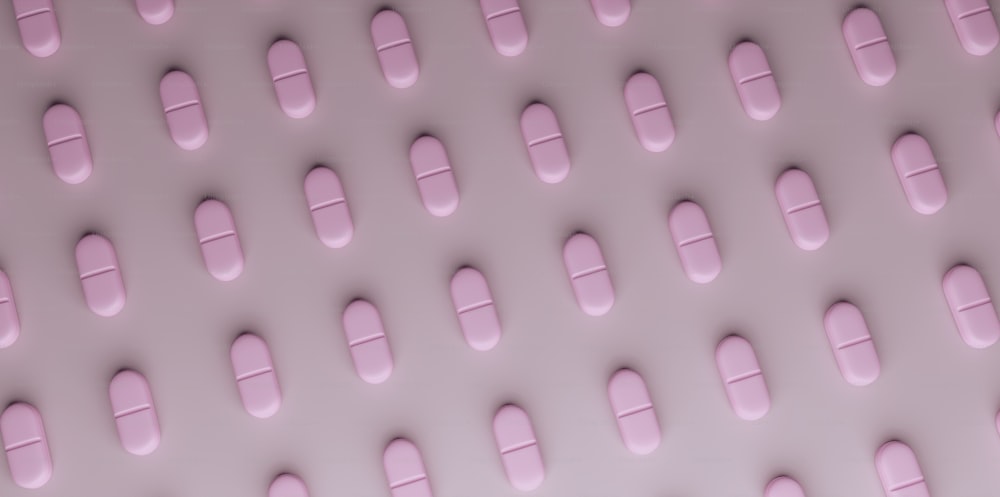 pink pills arranged in rows on a white surface