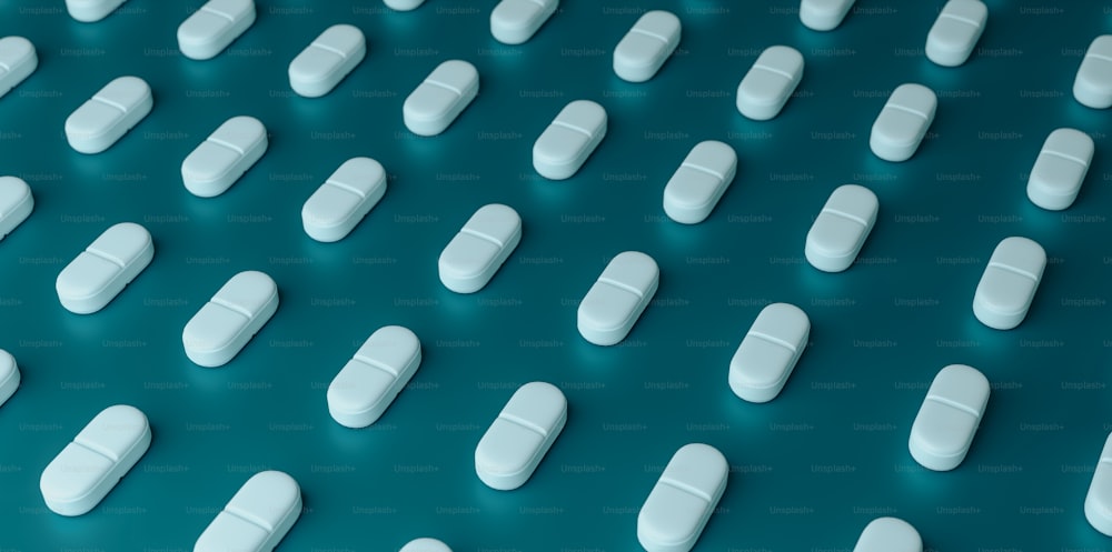many white pills lined up on a blue surface
