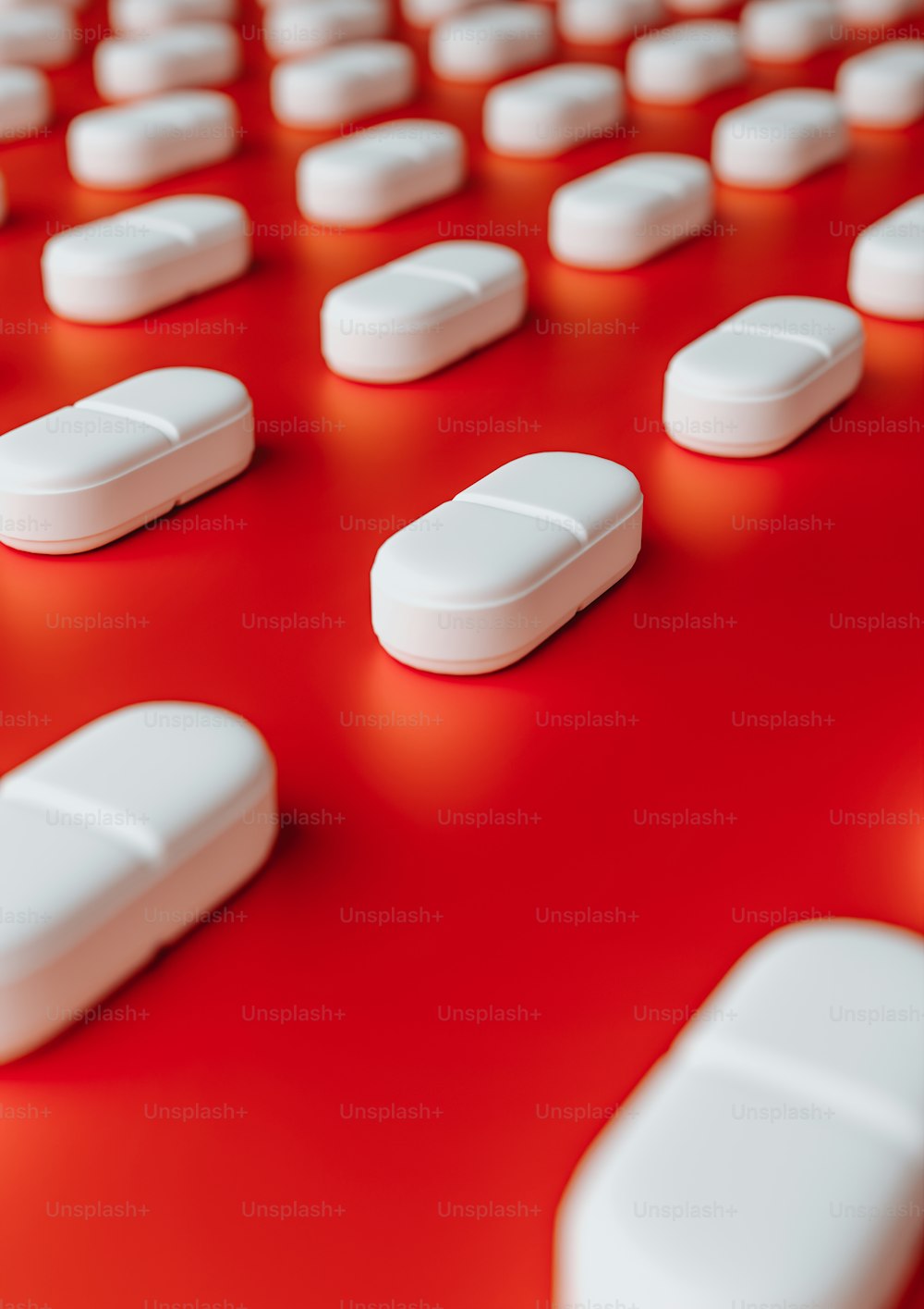 many white pills are arranged on a red surface