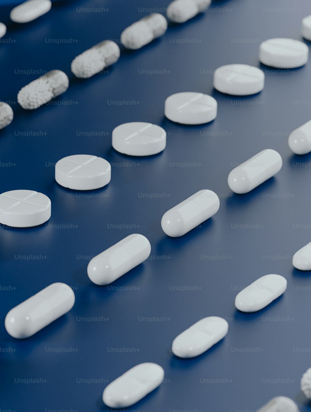 white pills lined up on a blue surface