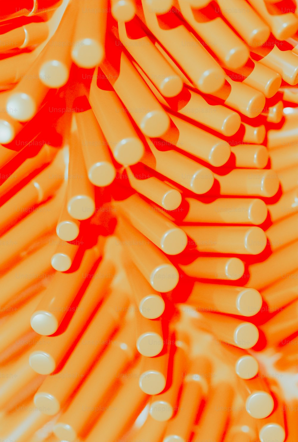 a bunch of orange and white toothbrushes stacked on top of each other