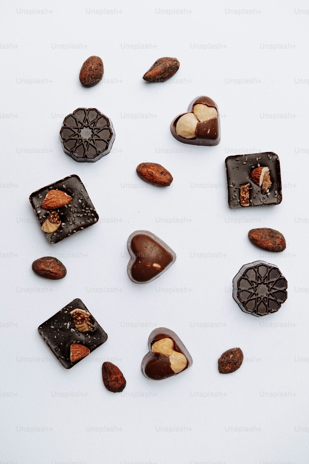 chocolates and nuts arranged in a circle on a white surface