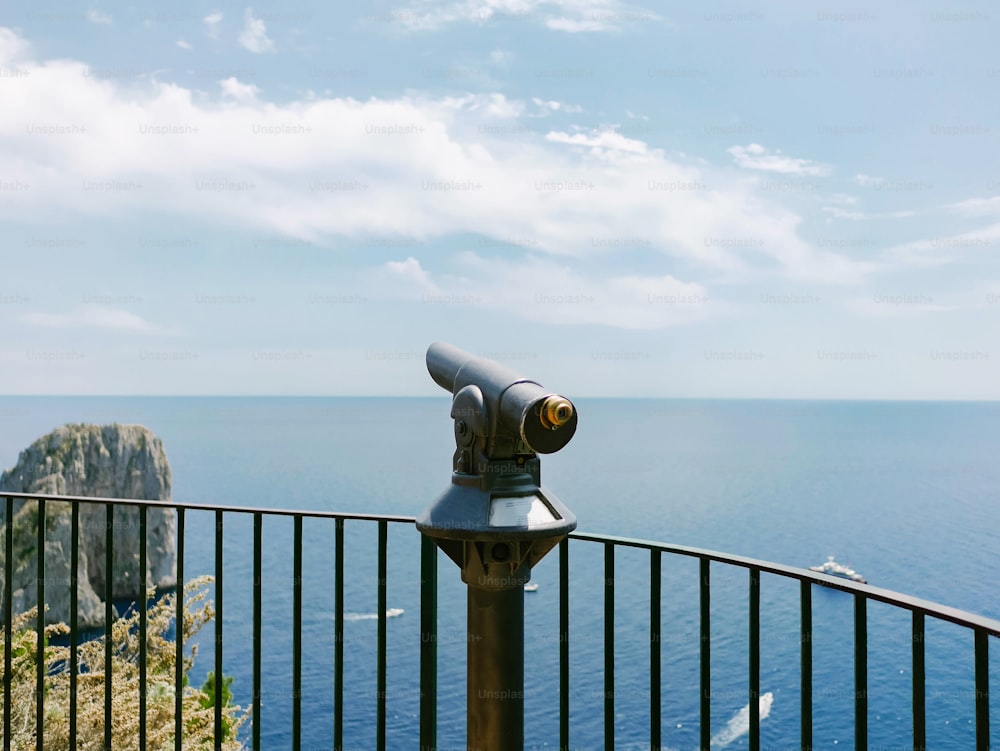 a telescope sitting on top of a metal fence